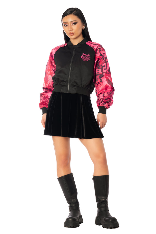 Back of the black cropped satin jacket showing bright pink tiger embroidery. League of Legends K/DA x BlackMilk cropped black satin souvenir jacket with pink Akali tiger artwork on the back and contrasting patterned sleeves.