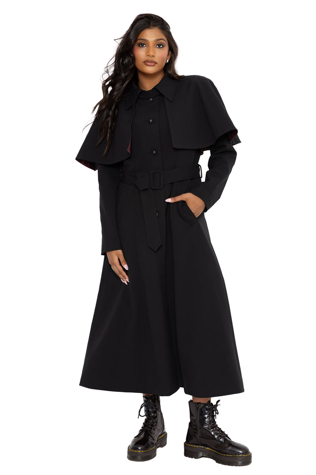 Corporate goth trench coat in all black with mystical occult inspired lining hidden beneath a sleek tailored silhouette. Featuring a removable cape overlay and longline fit, this fantasy witch coat combines gothic fashion with dark academia elegance.